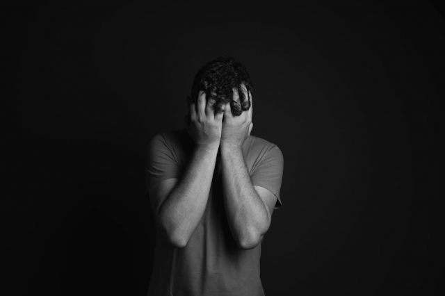 a man holding his head in his hands.