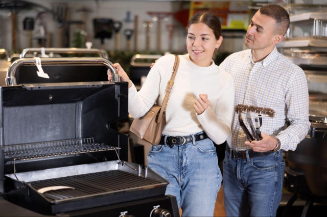 Photo of a couple browsing gardening supplies in a store, examining items on a display shelf as they look for the best gardening gifts for women.
