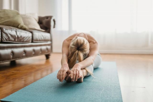 A woman doing yoga in her living room.