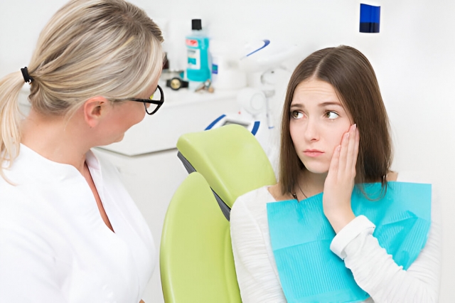 Young woman telling her dentist about dental caries