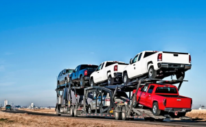 An auto transport with cars on a highway