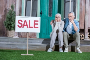 older couple in front of inherited house for sale