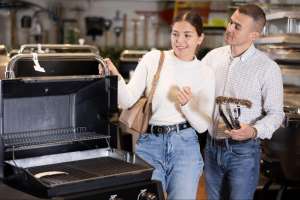 Photo of a couple browsing gardening supplies in a store, examining items on a display shelf as they look for the best gardening gifts for women.