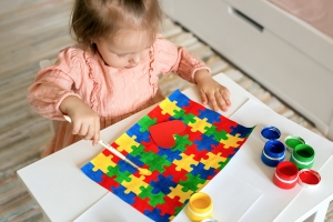 Child painting autism puzzles