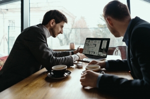 Two young businessman having a successful meeting at restaurant about partnering them for digital marketing services.