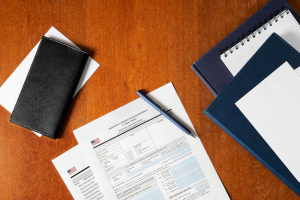  Documents and a pen on a wooden surface