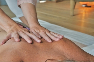 Therapist performing a gentle back massage to improve circulation and mobility