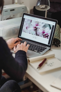 A woman looking at flowers delivery online shopping website on her laptop.