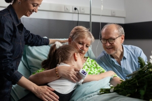 Little granddaughter bringing flowers while visiting sick grandmother