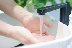 A person’s hands under running water