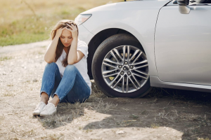 a person sitting next to a car