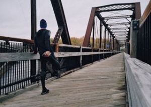 A man exercising on a bridge