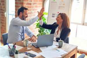 man and woman high-fiving in the office